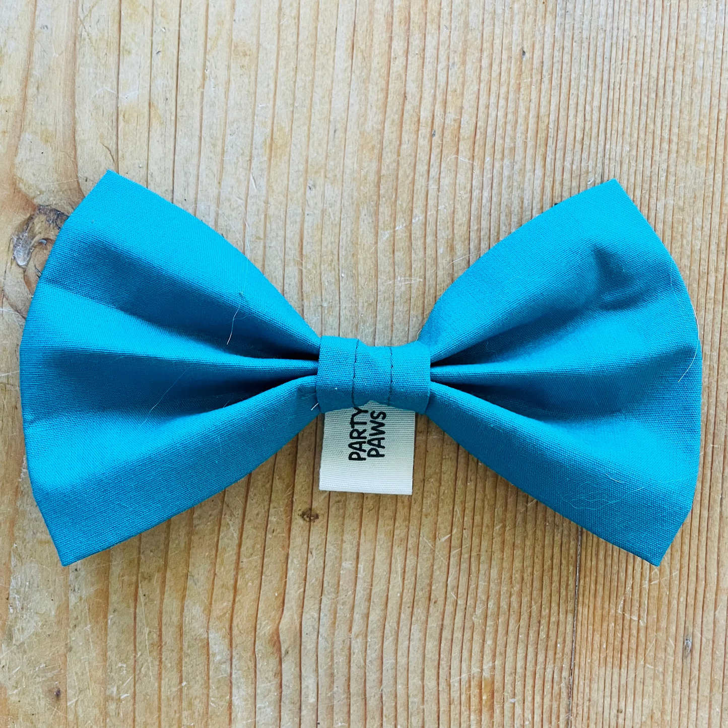 Vorderseite der petrolfarbenen Hundefliege aus Baumwollstoff